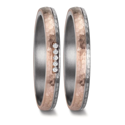 "Matching wedding ring set crafted from tantalum and 14K rose gold, featuring a hammered and brushed finish. The men's ring showcases a sleek design with two-thirds matte-finish rose gold and one-third brushed tantalum, separated by a finely engraved line. The women's ring mirrors this elegant contrast and is adorned with five pavé-set diamonds, adding a touch of brilliance to the refined, modern design