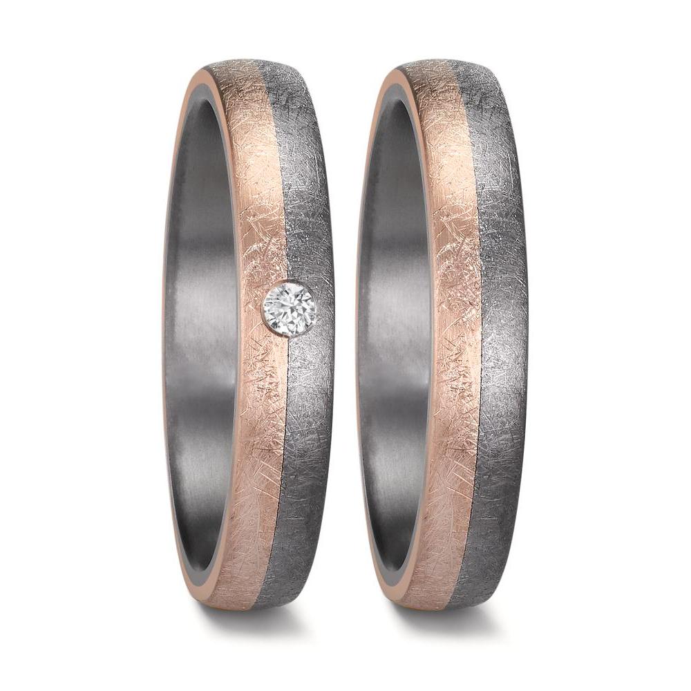 "Matching men's and women's tantalum wedding ring set with a comfort-fit design and a unique half-and-half swirl pattern. Both rings feature a striking sandblast-finish 14K rose gold section seamlessly blending into brushed tantalum. The women's ring is elegantly accented with a single diamond, set perfectly at the meeting point of the two metals, half in the tantalum and half in the rose gold, creating a modern and sophisticated look.