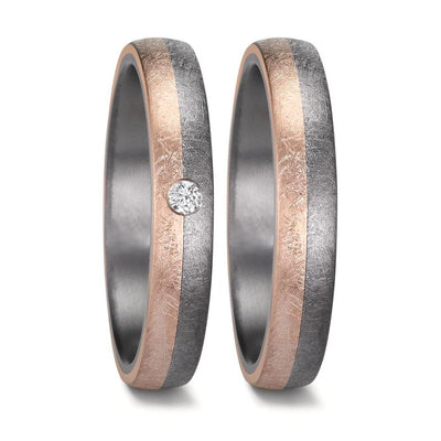 "Matching men's and women's tantalum wedding ring set with a comfort-fit design and a unique half-and-half swirl pattern. Both rings feature a striking sandblast-finish 14K rose gold section seamlessly blending into brushed tantalum. The women's ring is elegantly accented with a single diamond, set perfectly at the meeting point of the two metals, half in the tantalum and half in the rose gold, creating a modern and sophisticated look.