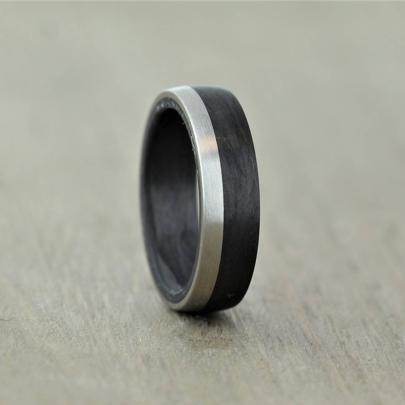 carbon fibre black wedding ring band with a palladium inlay. brushed finish 6mm wide court